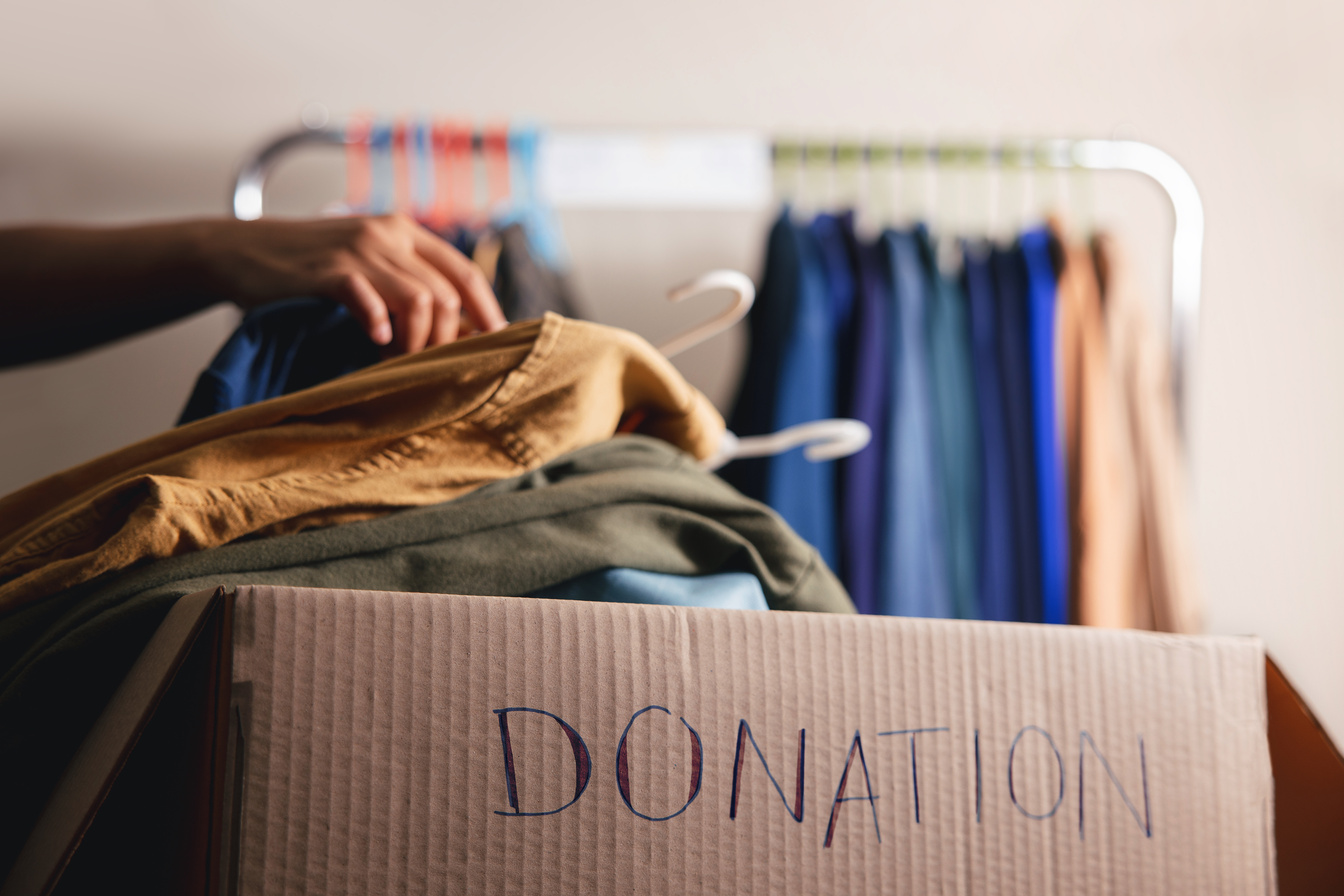 Donation Box with Old Clothes from Wardrobe Rack 